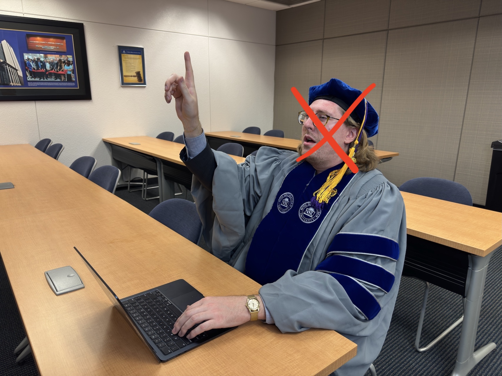 Exhibit B — Martin in graduation gown pointing
